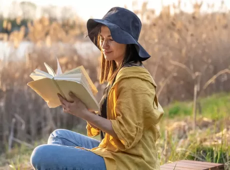 stylish-girl-with-a-book-in-her-hands-reads-at-sunset-.webp